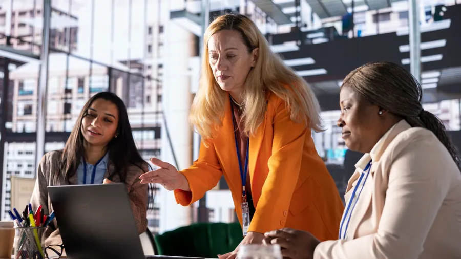 Women executives in a modern workspace collaborating on business strategy, leading a productive meeting. Successful businesswomen focusing on economic independence and breaking barriers.
