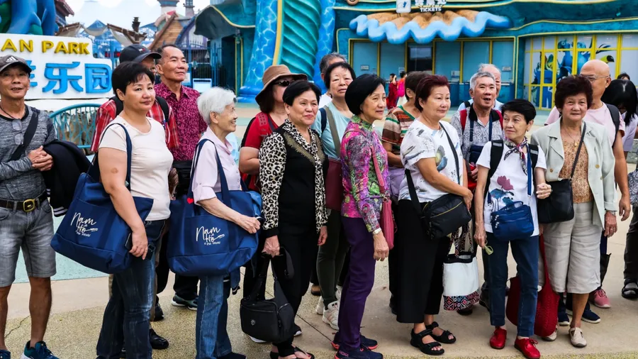 CHINA - 31 OCT 2023: Hainan. A group of seniors on a packaged tour of Fairyland Ocean Park. Travels and tours build strong friendship bonds and promote physical and mental wellness in the elderly.
