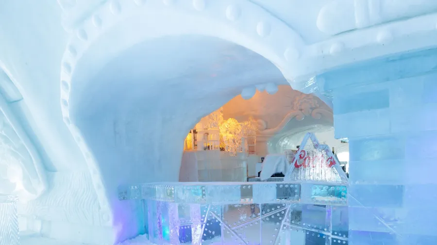 St-Gabriel-de-Valcartier, Quebec, Canada, March 1, 2023 - The bar in the world-renowned seasonal Ice Hotel illuminated in blue and gold