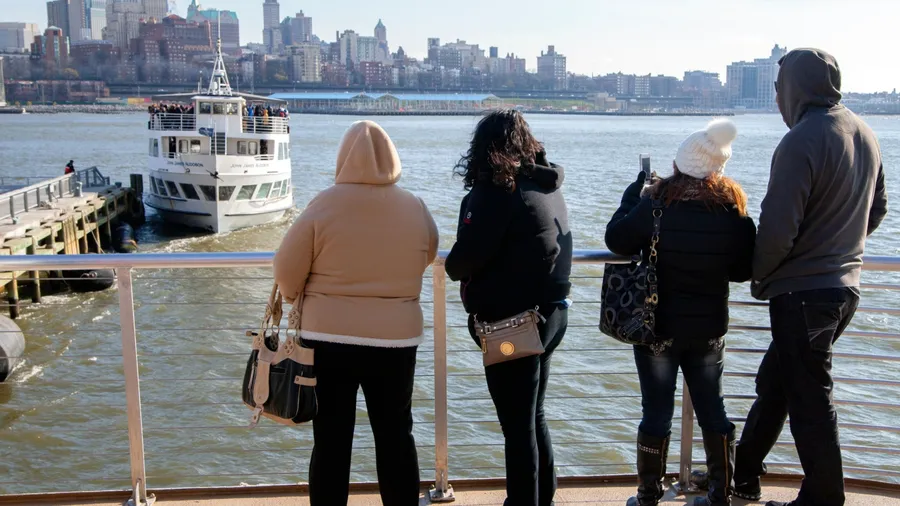 MANHATTAN , NEW YORK , USA - 2 of January 2016 :back view of people on the ship during the sightseeing tour with Brooklyn coastline on background. sunny winter day