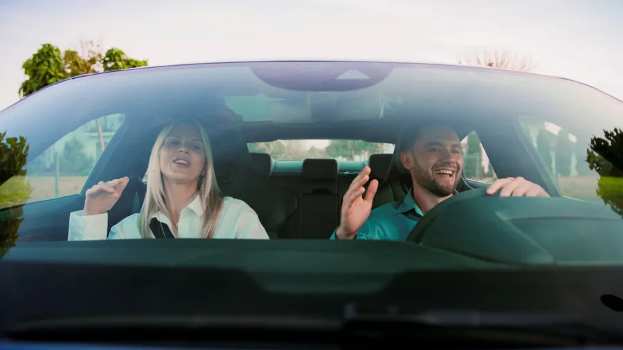Joyful Moments Friends Singing Together While Having Fun in the Car on a Road Trip. Friends joyfully singing karaoke together in a car, relishing a scenic drive bursting with vibrant energy