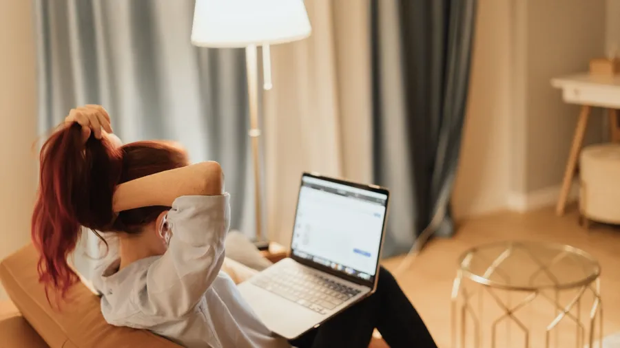 Young woman overwhelmed by online work from home while dealing with student loan stress and pressure of digital economy symbolizing financial anxiety and remote career uncertainty