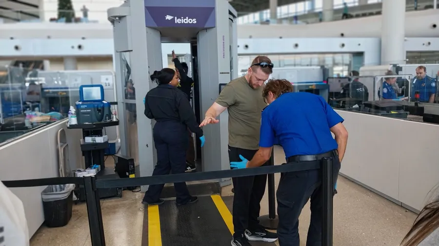 New Orleans - December 31, 2025: A departing passengers receives a is pat down at the TSA checkpoint in Louis Armstrong Airport
