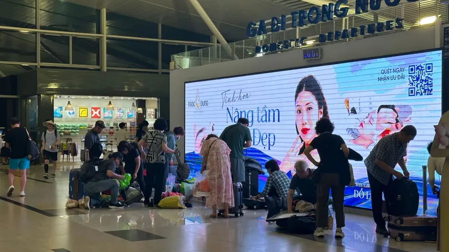 t Phu Quoc Airport, Vietnam – March 01, 2025: Passengers rearrange luggage to meet airline weight limits. Some sit on the floor while adjusting their bags.