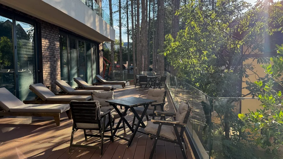 Sun drenched terrace invites tranquility with lounging chairs, evoking Valborg bonfires and retreating into Midsummers whispering pines