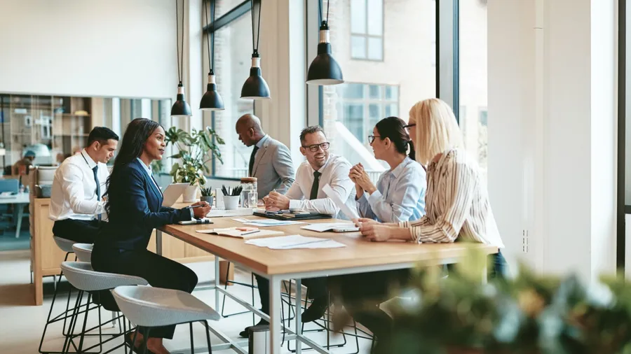 Smiling group of businesspeople together while having a meeting around a table