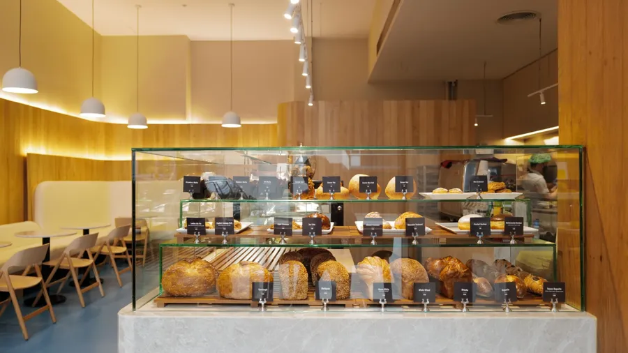 Interior counter design and bar decoration at 'HOLEY at Ruamruedee' local coffee cafe and bakery shop decorated with pastry display box and wooden furniture