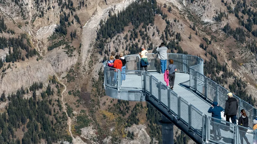 Jackson Hole Ski Resort, Wyoming, USA - October 6, 2023 - Incidental people enjoying the 360 degree views of the Teton Range from the Grand Teton Skywalk on the top of Mount Rendezvous