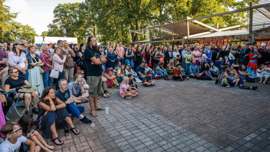 a diverse crowd of people including children and adults attentively