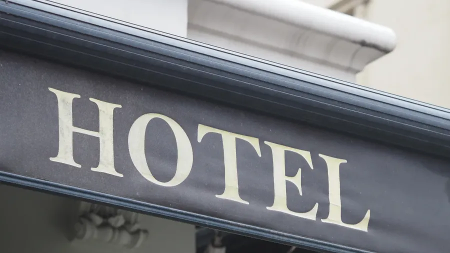 a large signage displays the word hotel in a busy
