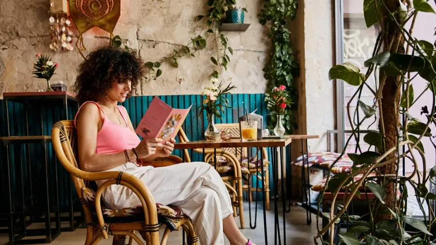a woman in stylish attire sits in a cafe in