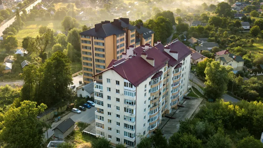 aerial view of multistory apartment buildings in green residenti