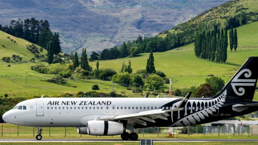 airplane of air new zealand takes off from airport