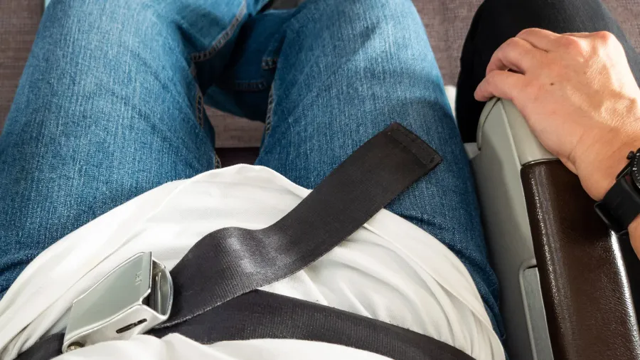 airplane passenger seated comfotably with seat belt seated fastened for