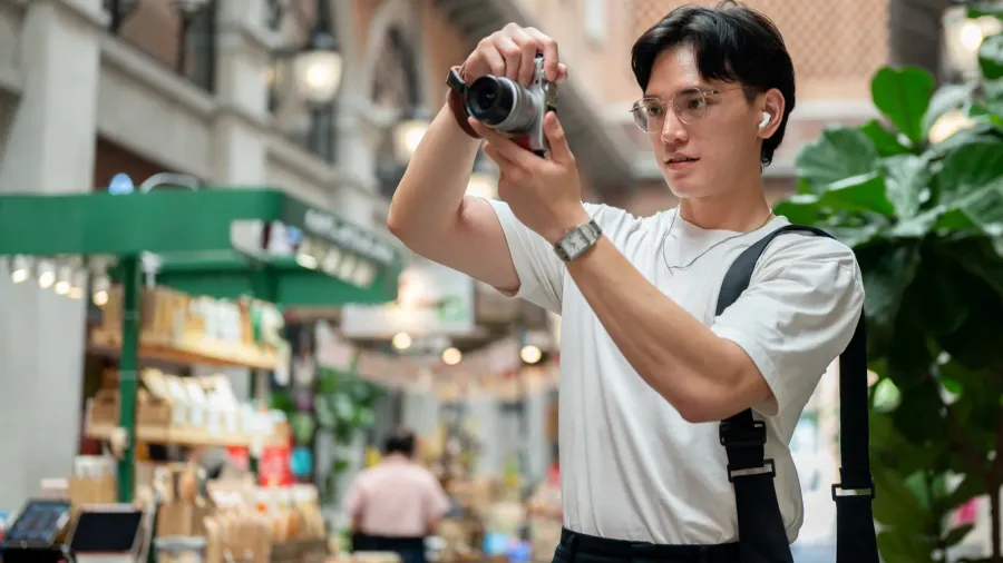 asian man wearing glasses in white tee is taking a