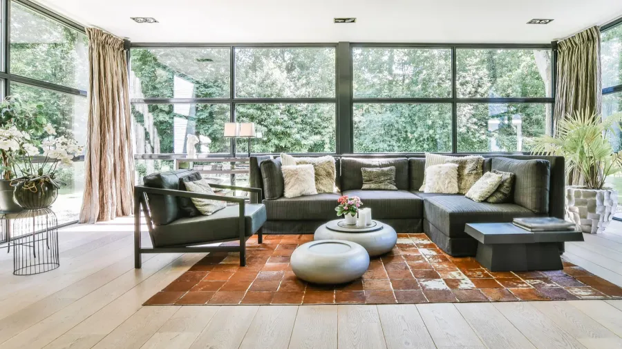 A stylish living room with large windows and cozy furniture.