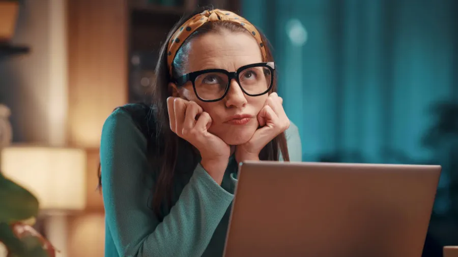 bored disappointed woman sitting at desk and working with her