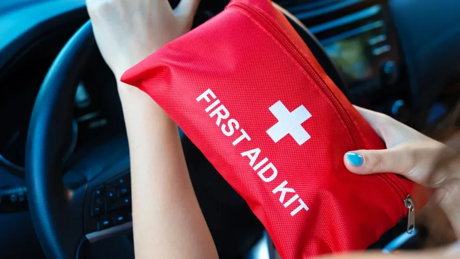 car first aid kit in female hands on a steering