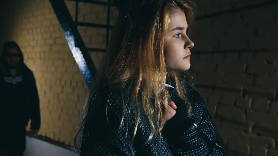 criminal observing young woman walking alone at night