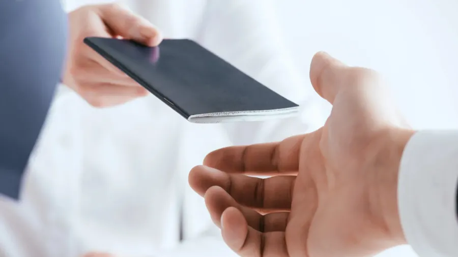 cropped view of travel agent giving passport to tourist isolated