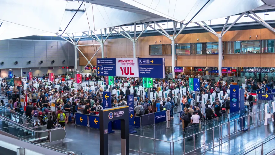 crowds of international passengers navigating immigration control at pierre elliott