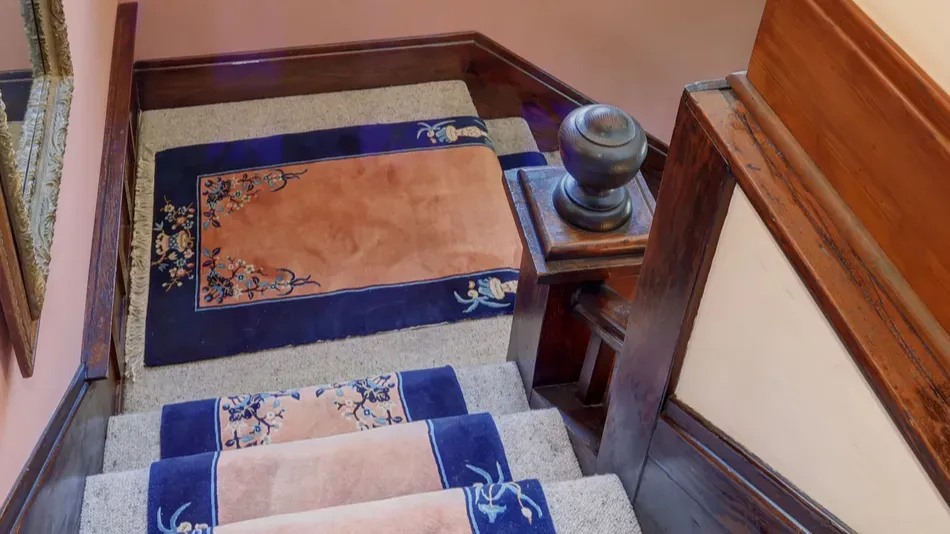 elegant staircase with blue rugs
