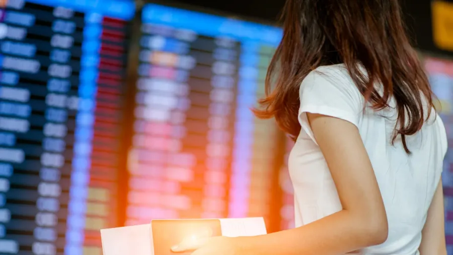 girl in international airport with passport and boarding pass