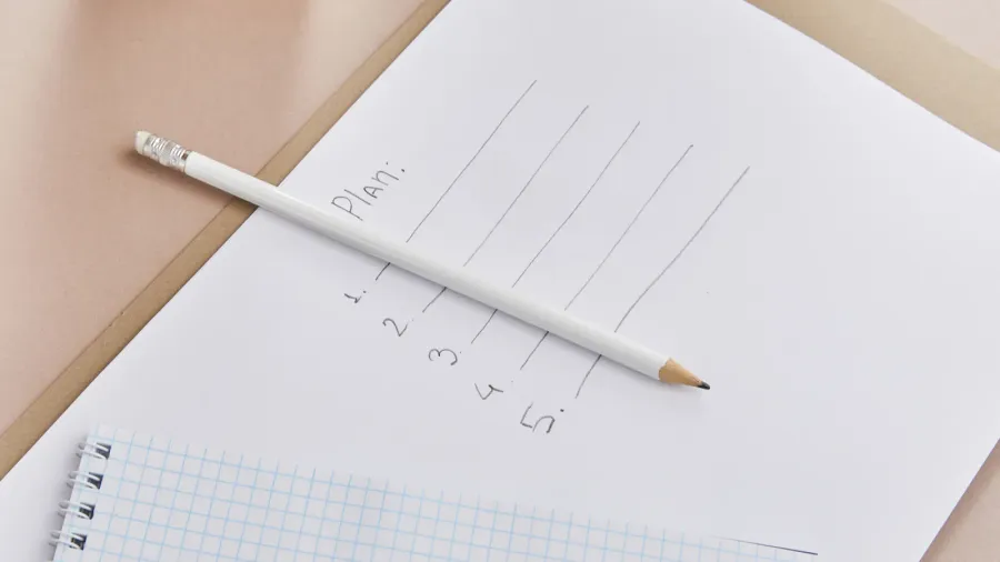 green plants blank notebook pencil paper with plan lettering on