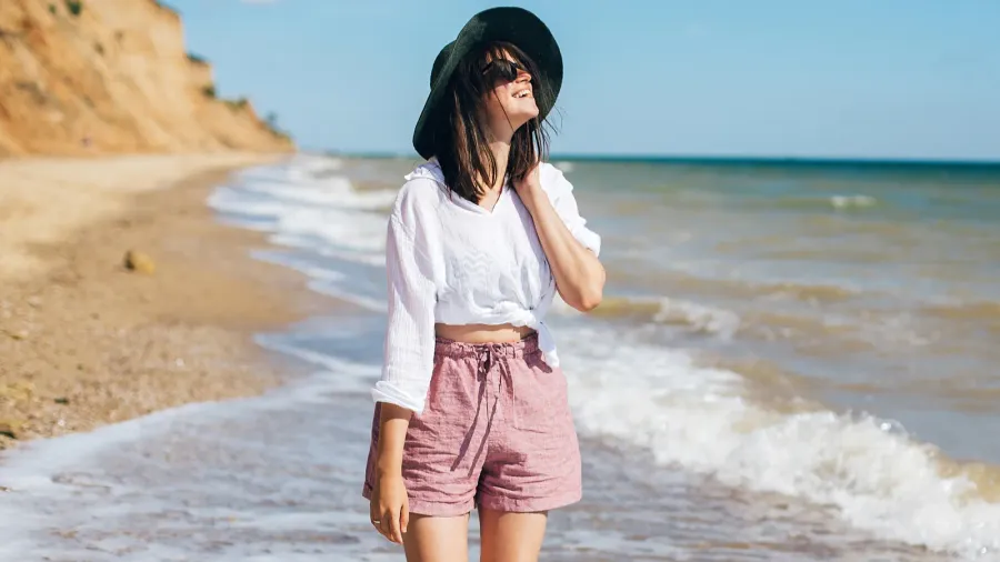 happy young boho woman walking and having fun in sea