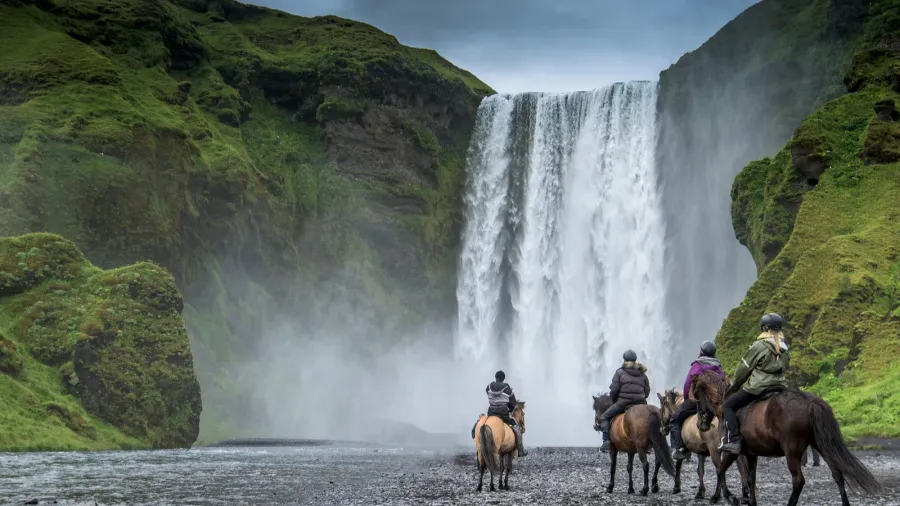 horse rider near skogafoss waterfall in summer iceland
