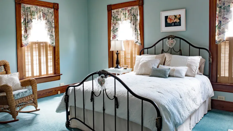 iron bed in teal bedroom of old victorian home