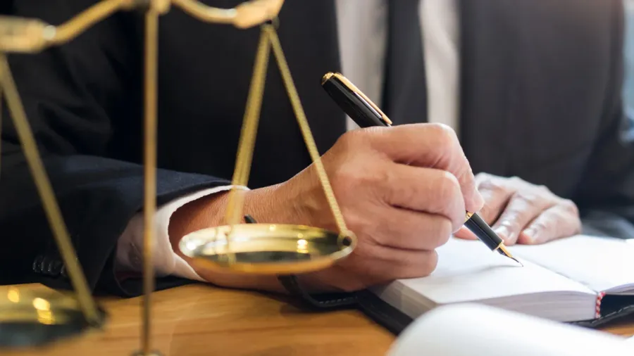 male lawyer working with contract papers and reading law book