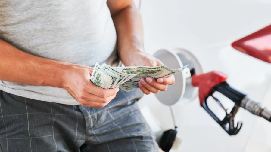 man counting money he need to spend on fuel transportation