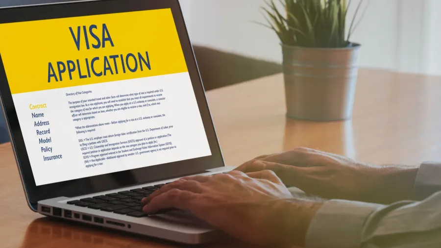 man doing visa application by internet with a laptop