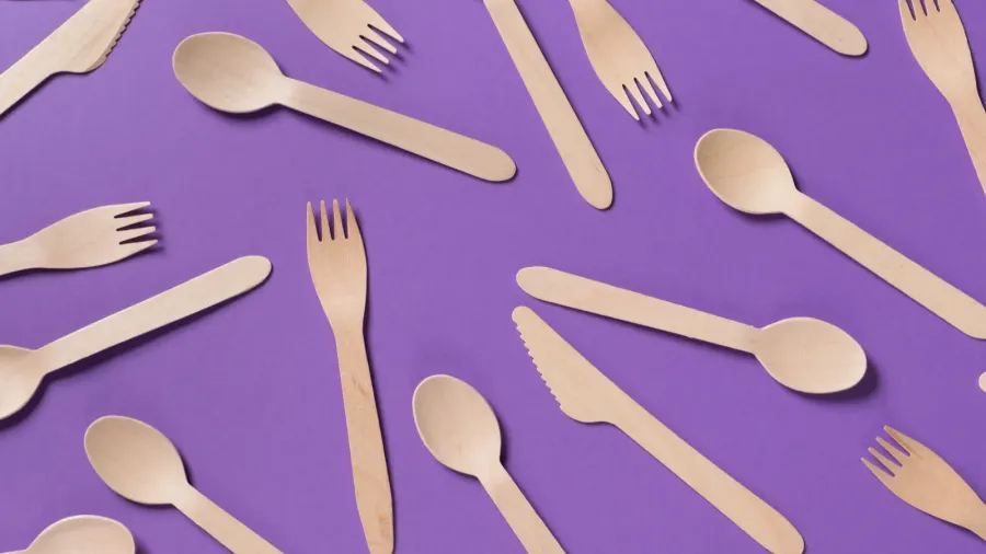 many wooden spoons on purple background top view