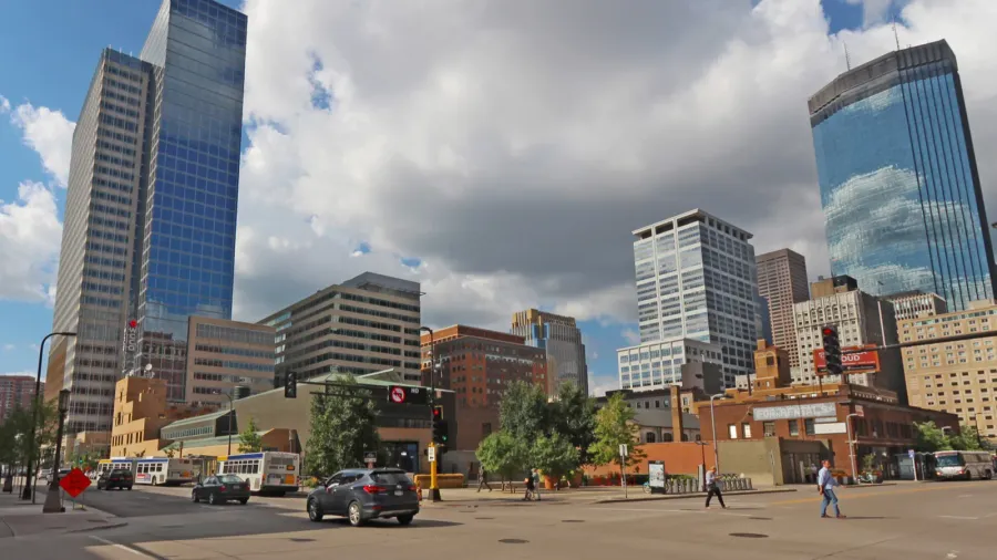 pedestrain and car traffic and a partial skyline of minneapolis