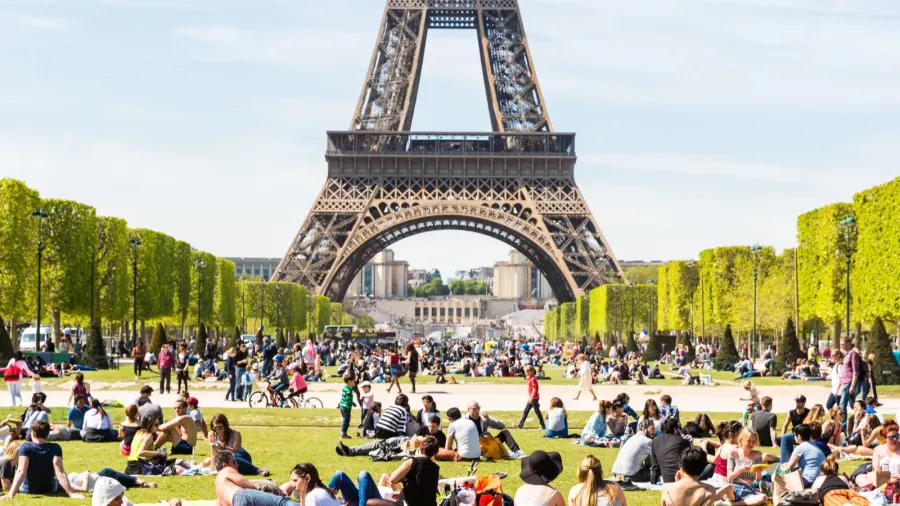 people on champ de mars with eiffel tower on background