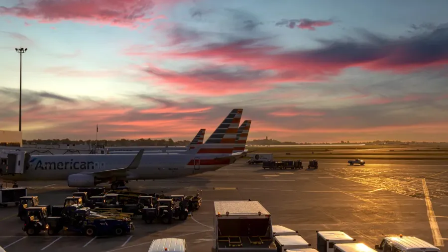 planes departing from boston logan airport at sunset