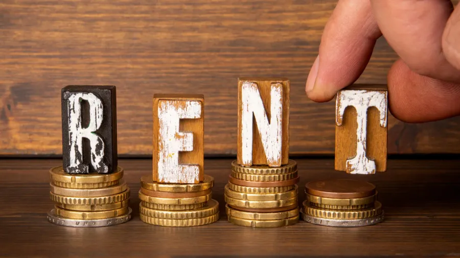 rent concept alphabet blocks and change on wood texture background