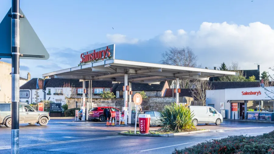 sainsburys fuel station with vehicles queuing on a sunny winter