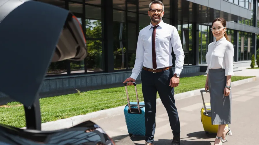 selective focus of smiling business people walking with suitcases to