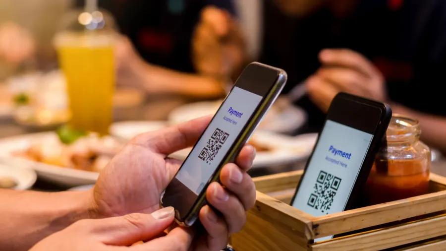 selective focus to smart phone in hand to scan qr