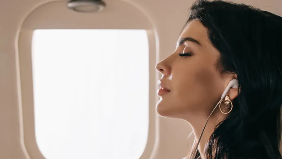 side view of attractive businesswoman with closed eyes listening music