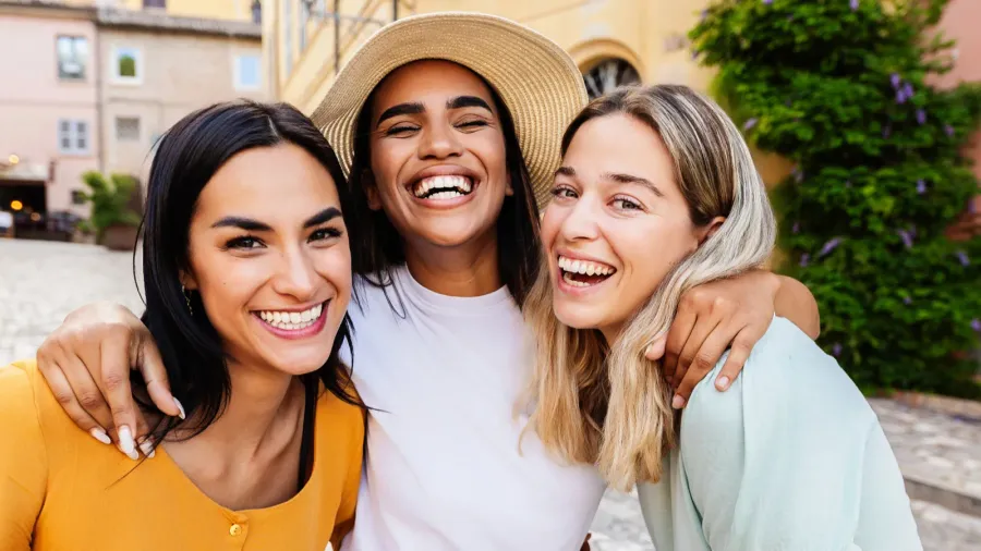 smiling portrait of small group of three young women laughing