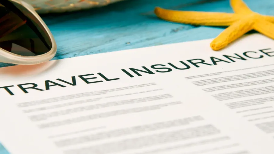 sunglasses straw hat and travel insurance policy