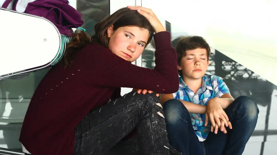 teen boy and girl waiting in the airport