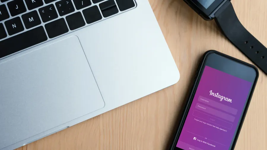top view of laptop smartwatch and smartphone with instagram website