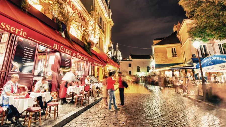 tourists and locals walk in montmartre streets