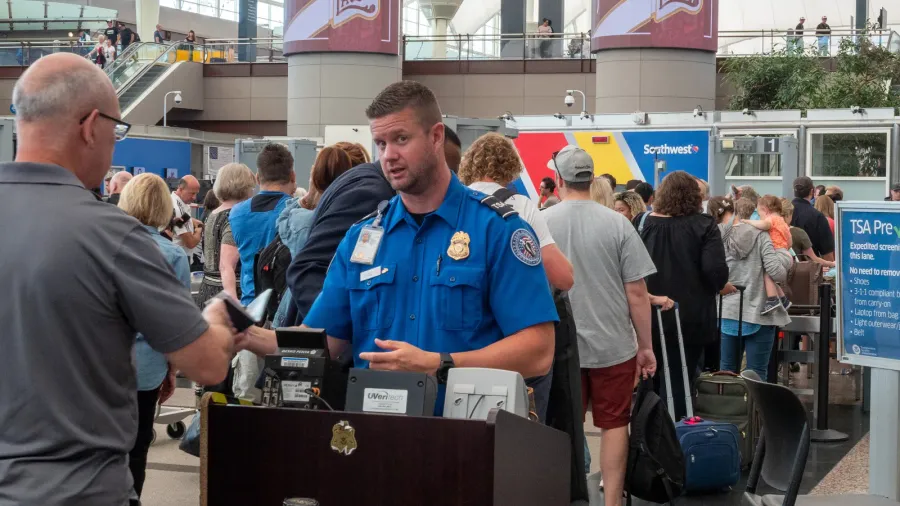 tsa agent passes man through security checkpoint at denver international