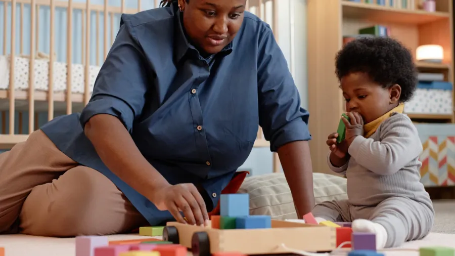 young mother of black ethnicity playing with little baby girl